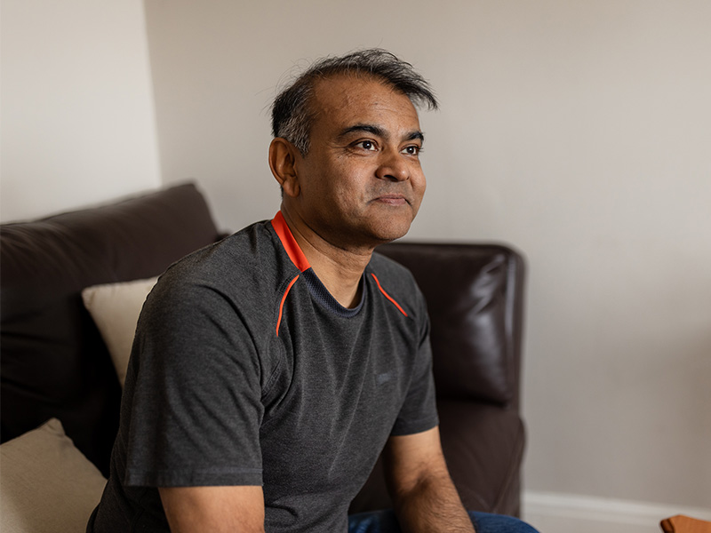 Amir sat inside in his living room.