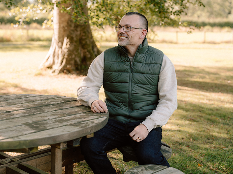 Ben sitting outside on a bench.