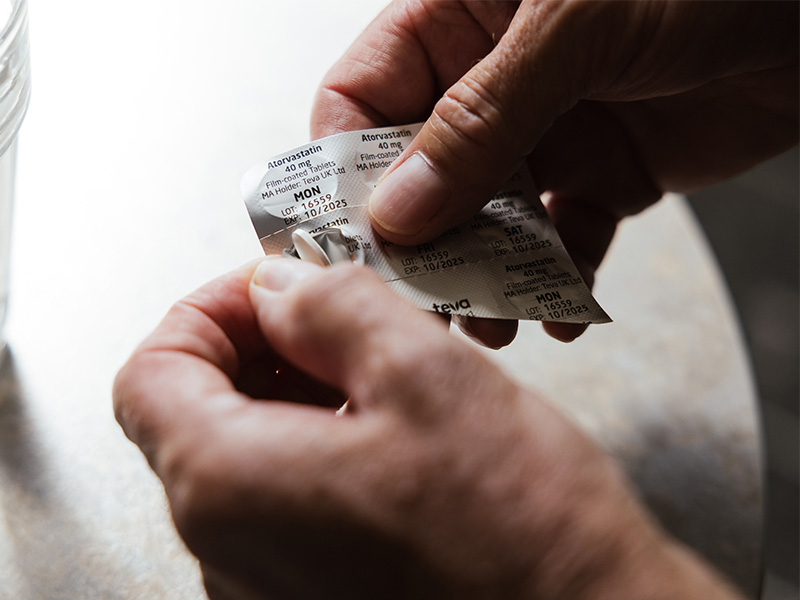Nigel holding a blister pack of his statin medicine.