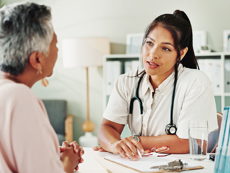 Mature woman visiting her GP doctor NHS