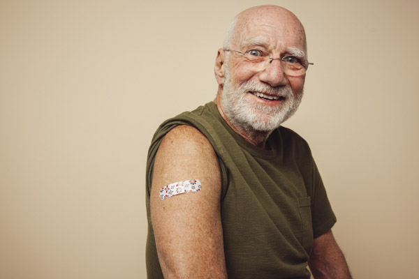 A person smiling with a plaster on their upper arm