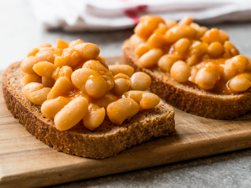 Two slices of toast with baked beans.