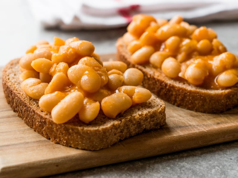 Two slices of toast with baked beans.