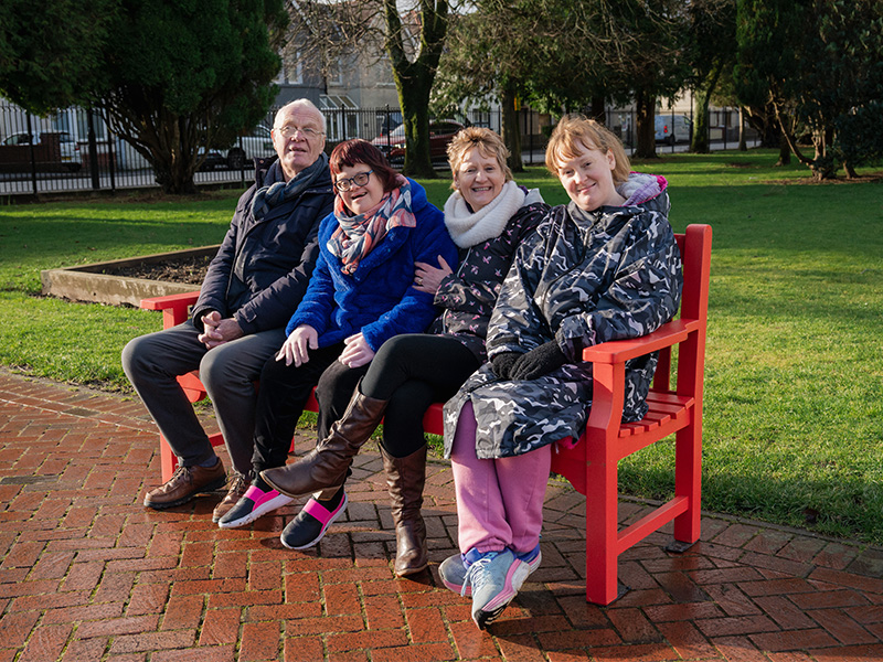Sara with her dad Andy, mum Ann and sister Joanne on a bench.