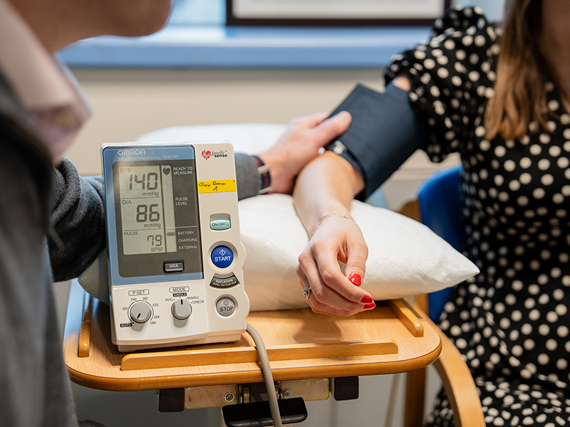 Professor Wilkinson measuring someone's blood pressure with a monitor.