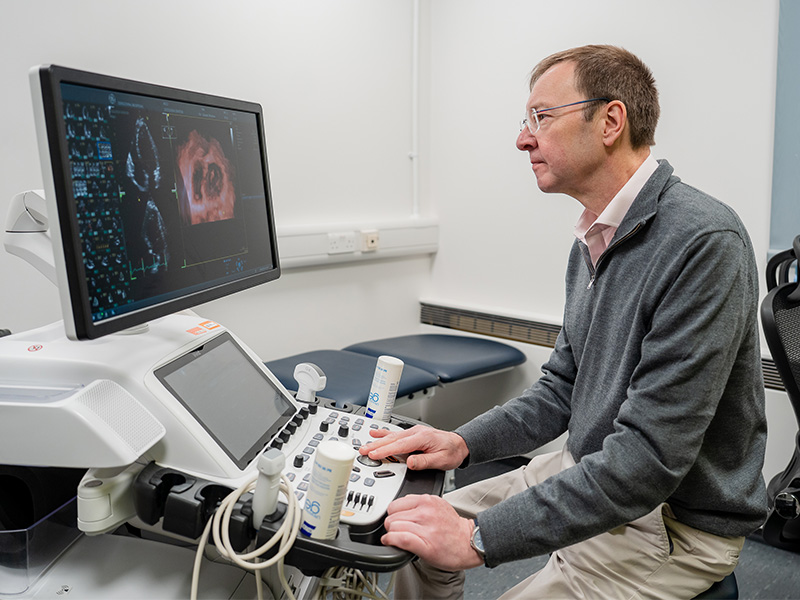 Professor Wilkinson looking at echo scans to see the effect of high blood pressure on the heart.