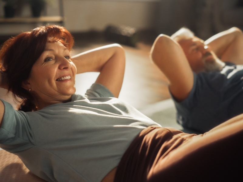 A woman and man performing abdominal crunch exercises.
