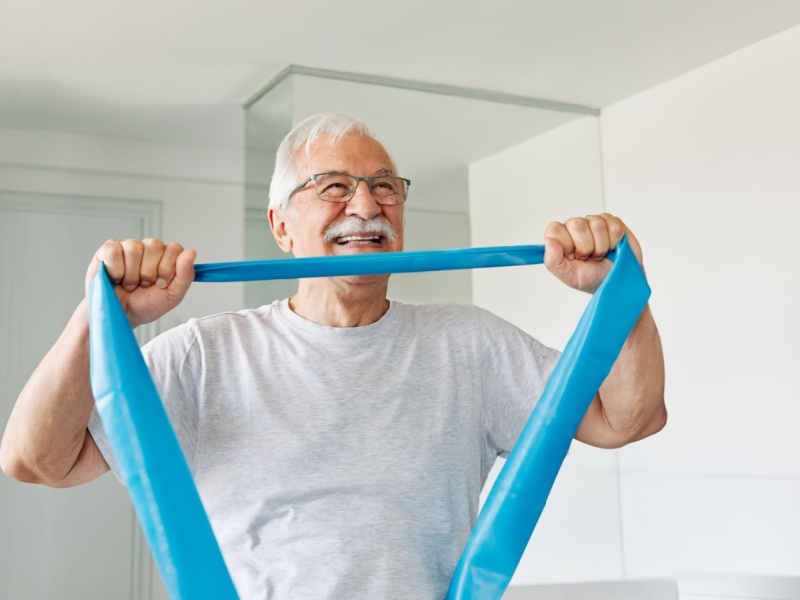 A man exercising with a resistance band.