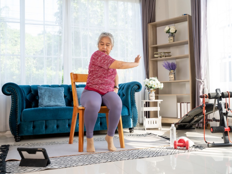 A woman performing seated exercises at home.