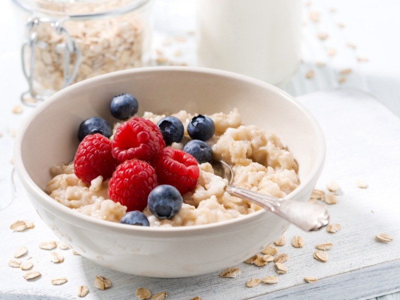 A bowl of porridge oats with raspberries and blueberries.
