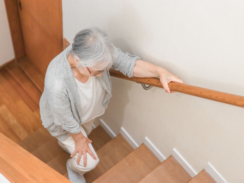 A woman walking up stairs inside her home.