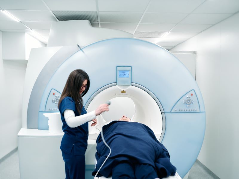 Technician standing by an MRI scanner
