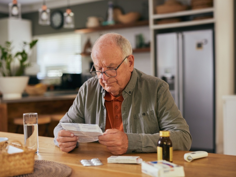 A man reading a statin patient information leaflet.