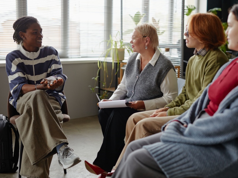 A group of people sitting in a circle and talking.