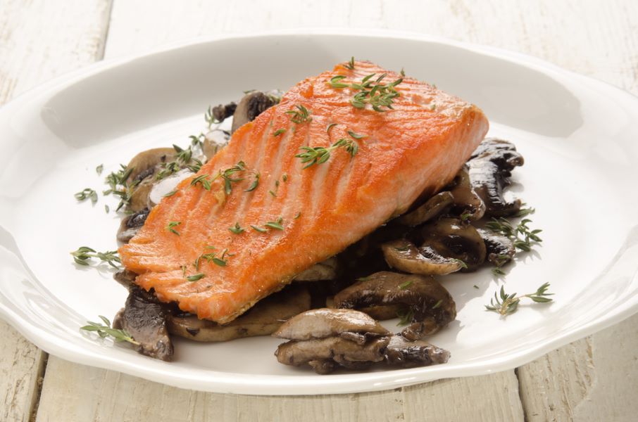 Baked salmon fillet on a bed of cooked mushrooms