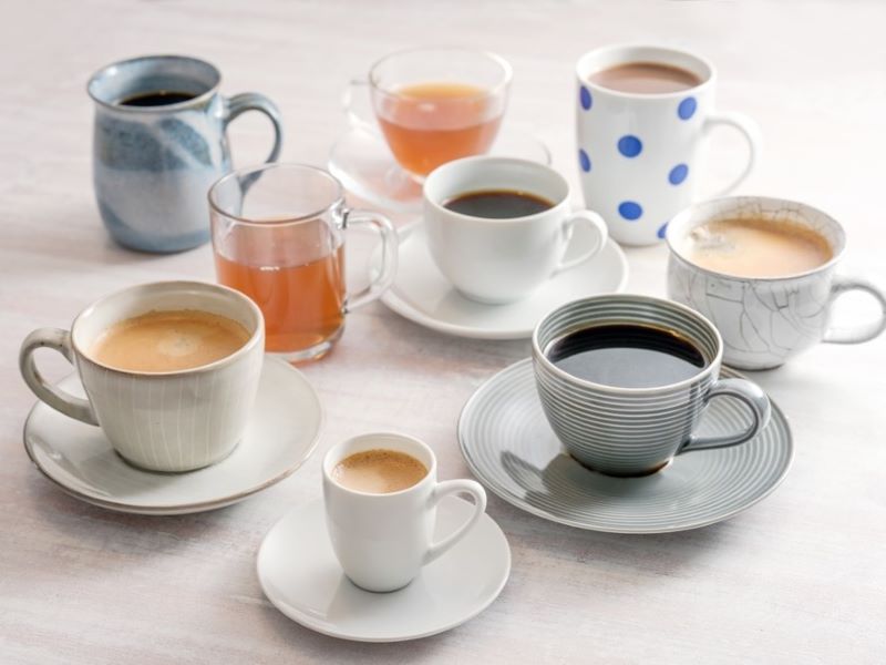 Different cups of teas and coffees on a table.