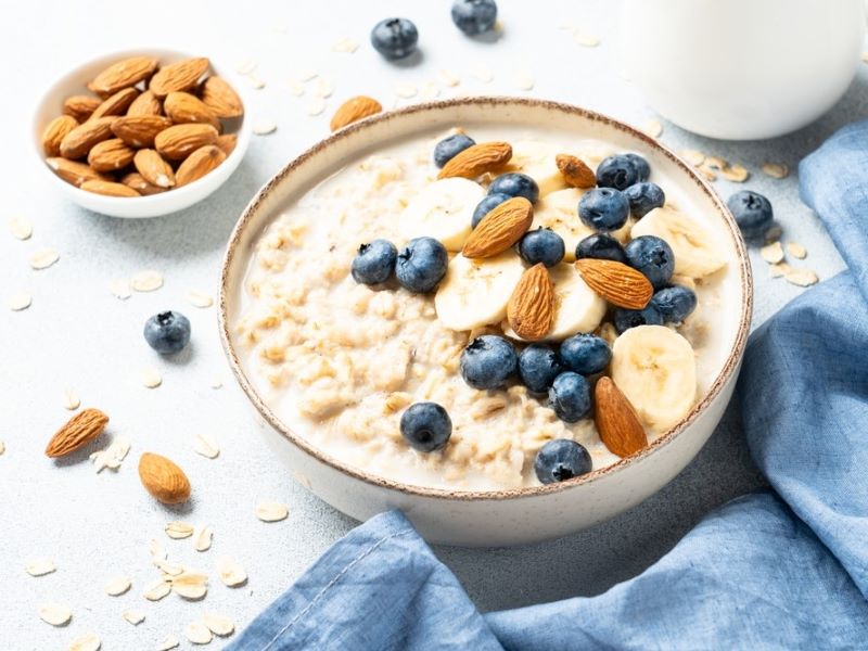 A bowl of porridge with blueberries and almonds.