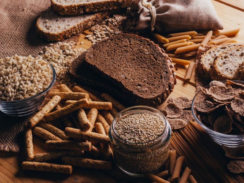 Wholegrains on a table, including rye bread, ancient grains and wholewheat pasta.