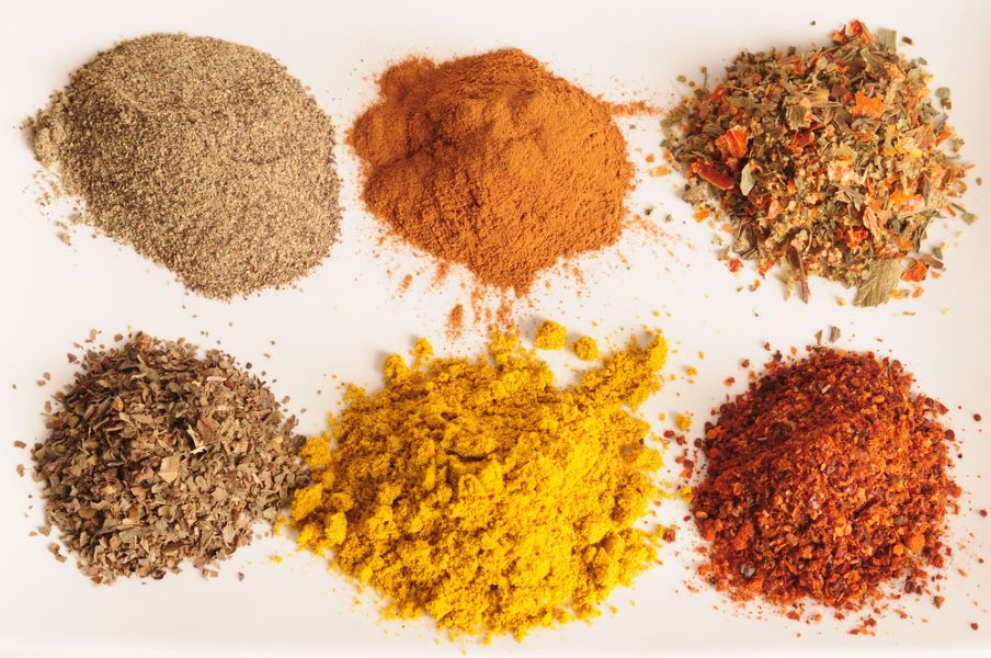 Small piles of different herbs and spices.