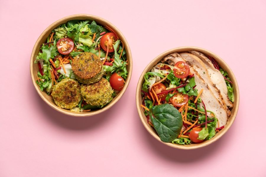 Fresh, healthy-looking meals in carboard takeaway boxes.