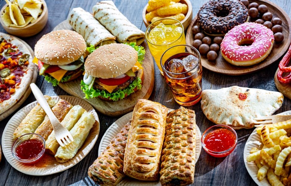 A spread of ultra-processed foods including burgers, sausage rolls and doughnuts.