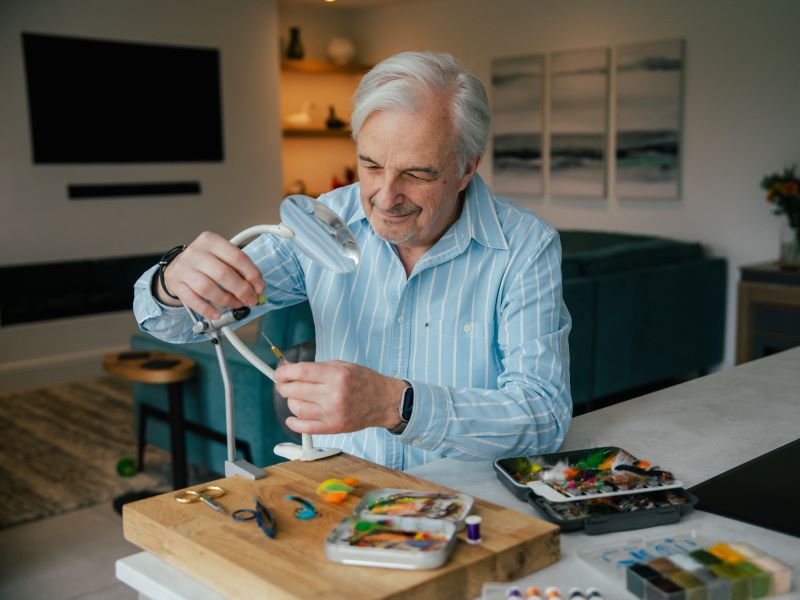 Paul creating a fly using a bobbin holder and pliers for fly fishing.