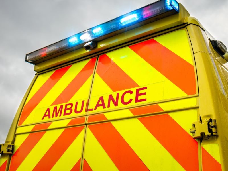 Back of a UK ambulance with red and blue lights flashing