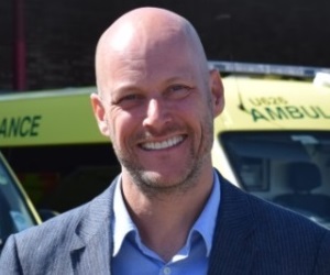 Dr Mark Griffiths, Consultant Clinical Psychologist, wearing a grey suit and light blue shirt.