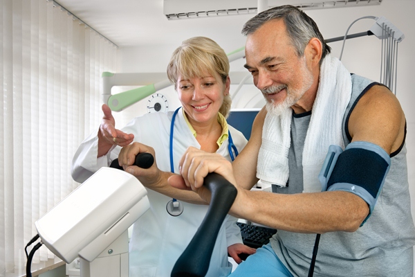 Man uses exercise bike under guidance of health care professional 