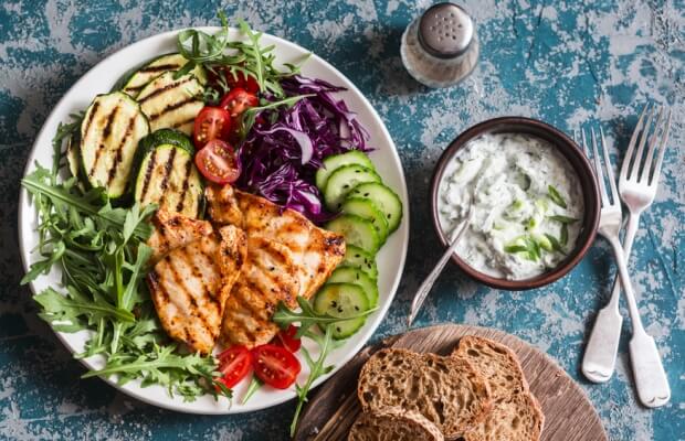 Healthy meal of grilled chicken with vegetables, yoghurt and wholemeal bread