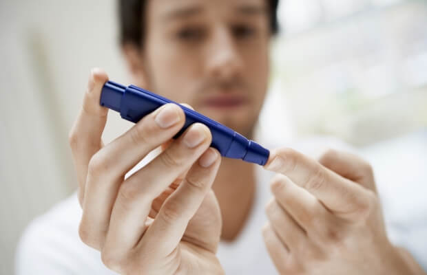 Diabetic man using a lancet