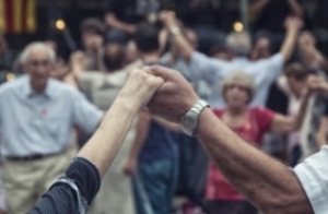 A group of older people dancing with hands held and arms raised. Close up of old man and old ladies holding hands aloft as part of the dance.