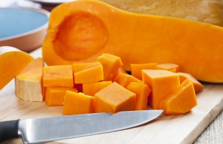 butternut squash on chopping board with knife