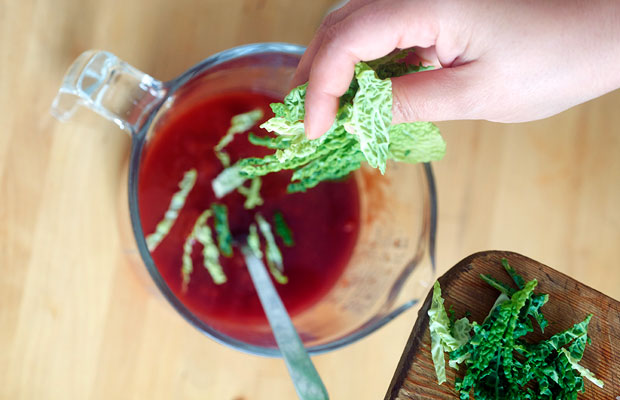 Stiring shredded cabbage leaf in tomato mixture