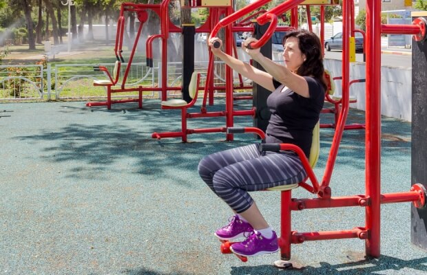 A woman using an outdoor gym