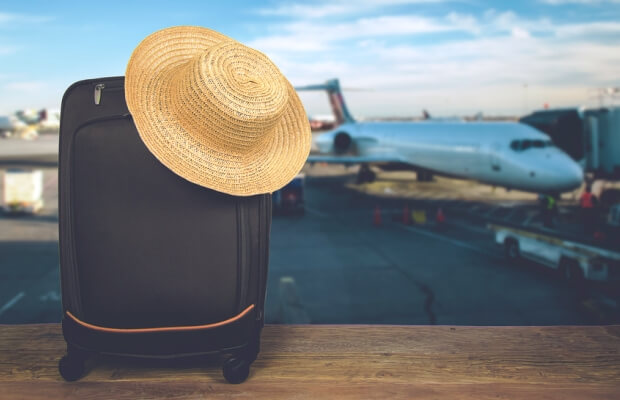 Suitcase and sun hat in an airport departure lounge