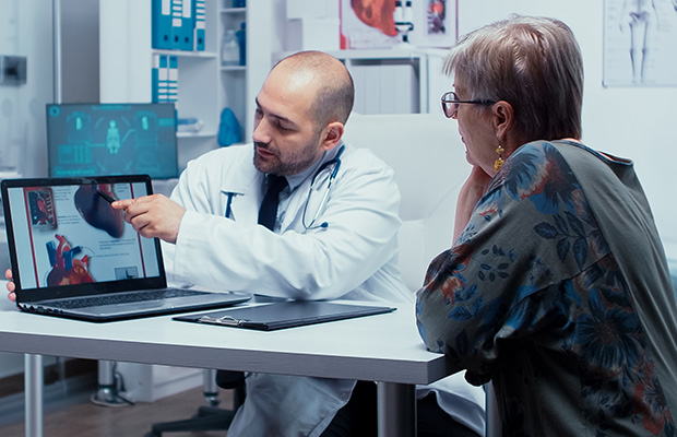 A doctor showing a woman a diagram of the heart.