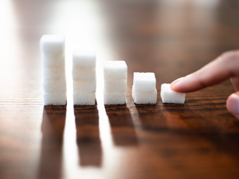 Piles of sugar cubes on a table getting smaller from left to right.