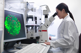 Lady with microscope in biolab