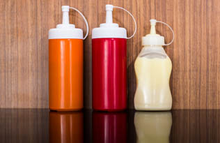 Mustard, ketchup and mayonnaise sauce bottles lined up