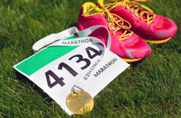 A marathon medal, running number and trainers