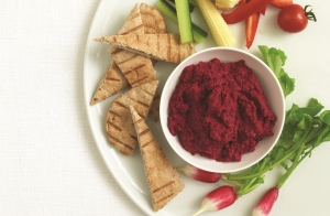 A portion of beetroot hummus with pitta and vegetables