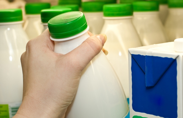 Hand picking up bottle of specialist milk
