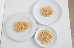 A portion of spaghetti on different sized plates