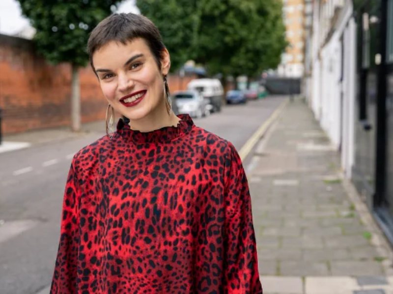 A woman on a pavement smiling
