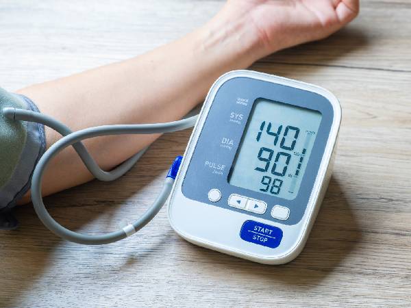 a blood pressure monitor with a high blood pressure reading attached to a man's arm