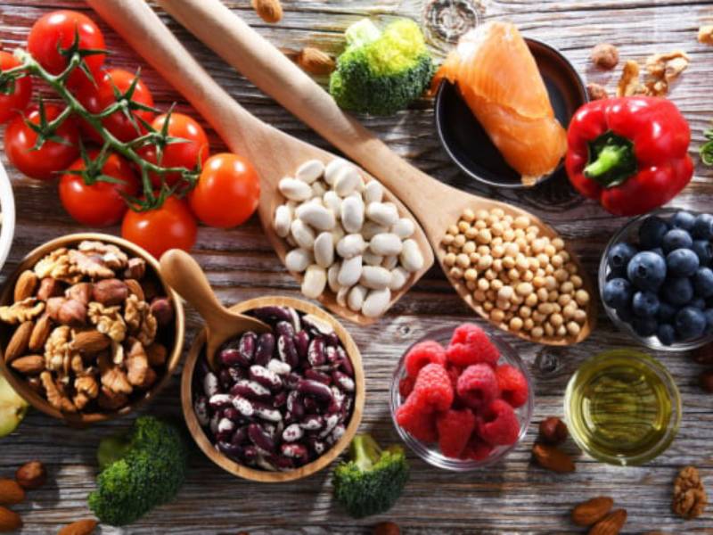 A selection of healthy foods including vegetables, nuts and legumes.