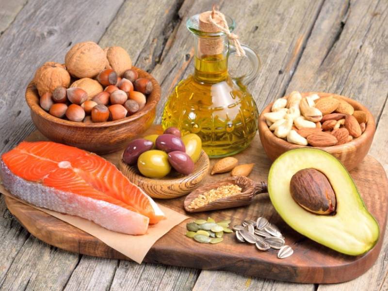 A selection of foods containing healthy fats such as avacado and salmon.