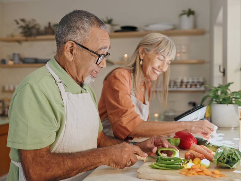 A couple prepare a healthy meal at home in their kitchen.