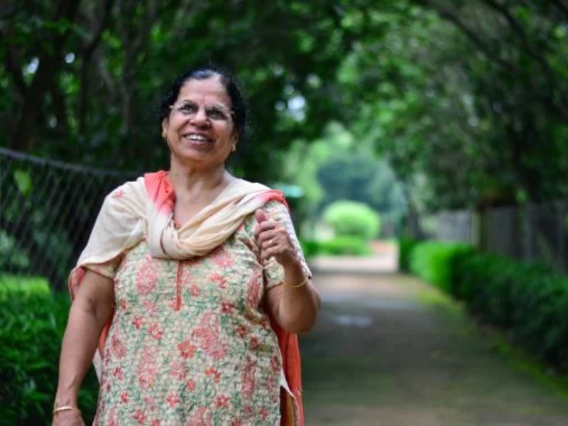 A woman outside in a park smiling
